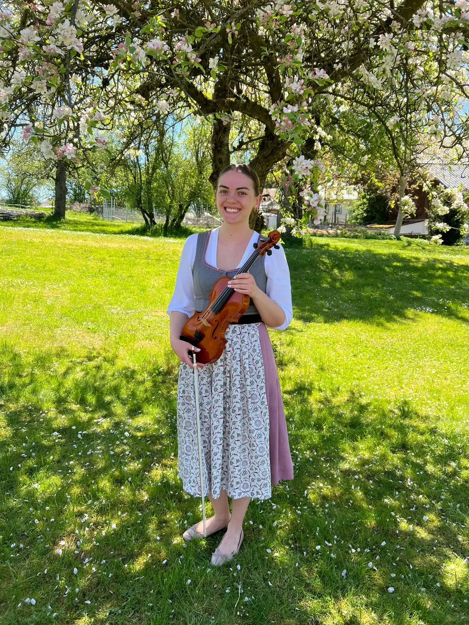Lisa Haindl mit ihrer Geige im blühenden Obstgarten