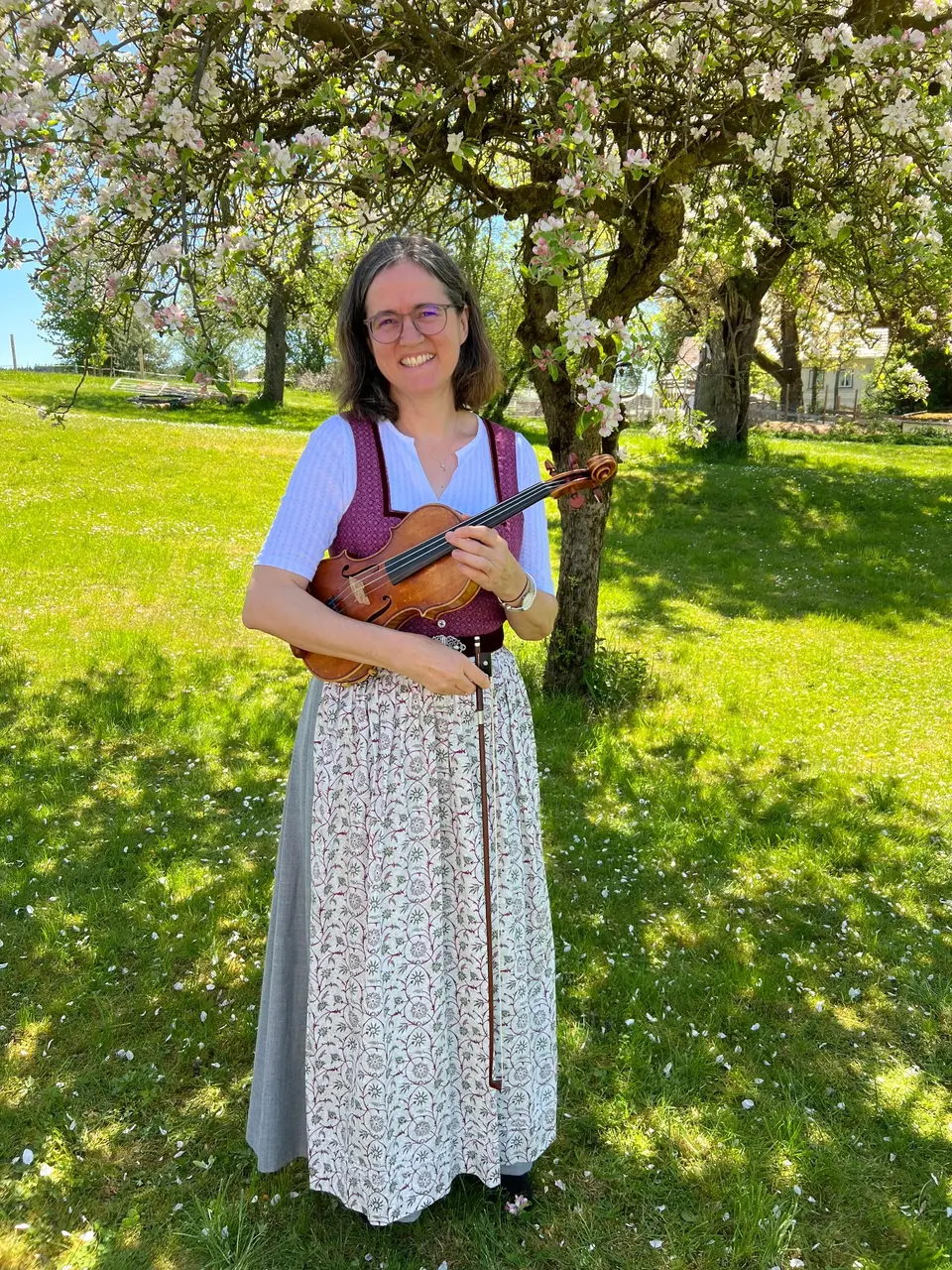 Lisa Müller-Haindl mit ihrer Geige im blühenden Obstgarten