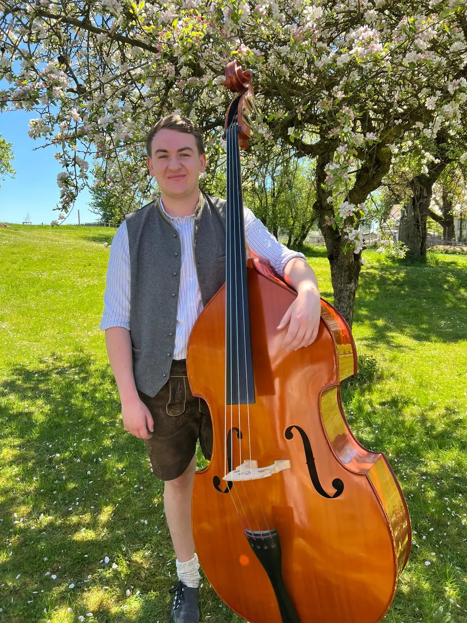 Thomas Haindl mit seinem Kontrabass im blühenden Obstgarten